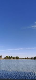 Scenic view of lake against clear blue sky