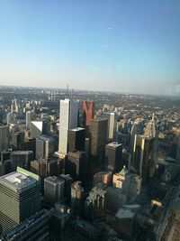 Aerial view of buildings in city against clear sky