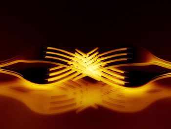 Close-up of illuminated lamp over black background