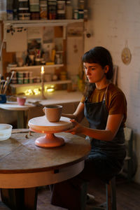 Relaxed woman spend evening in pottery studio busy with handwork after stress at work. art therapy