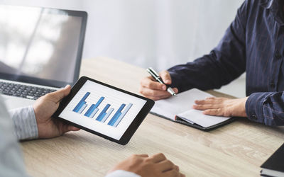 Midsection of man using laptop on table