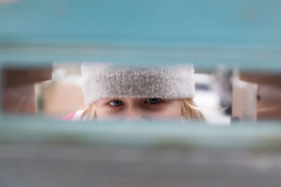 Close up portrait of girl seen through hole