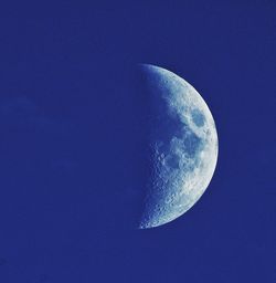 Low angle view of half moon against blue sky