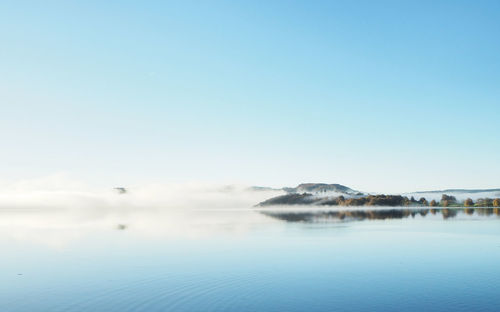 The stunning view of foggy morning covers the mountain and lake windermere in late summer 