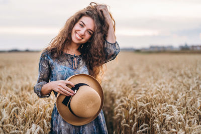 Beautiful young woman standing in a field