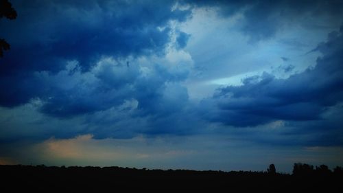 Low angle view of sky over silhouette field