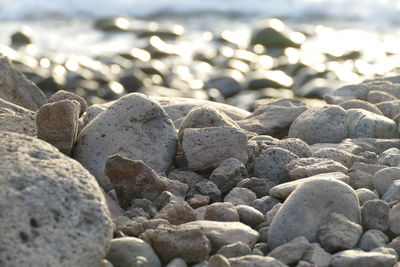 Close-up of pebbles on beach against sky