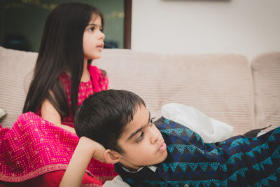 Brother and sister relaxing at home