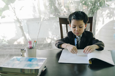 Full length of a boy sitting on table