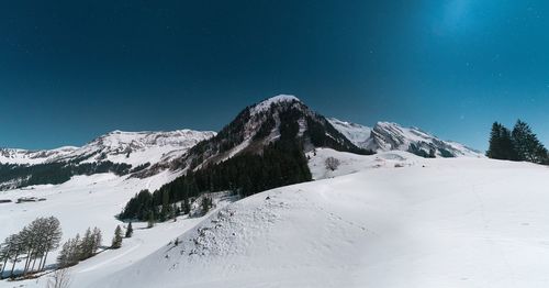 Scenic view of snowcapped mountains against clear blue sky