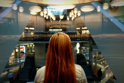 Rear view of woman walking in illuminated city