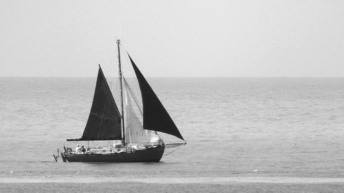 People traveling in boat on sea against clear sky