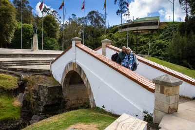 Couple standing on bridge over canal