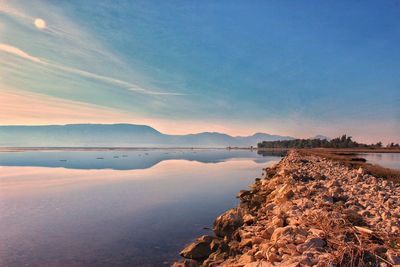 Scenic view of lake against sky at sunset