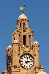 Low angle view of clock tower against clear sky