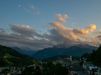 Aerial view of townscape and mountains against sky at sunset