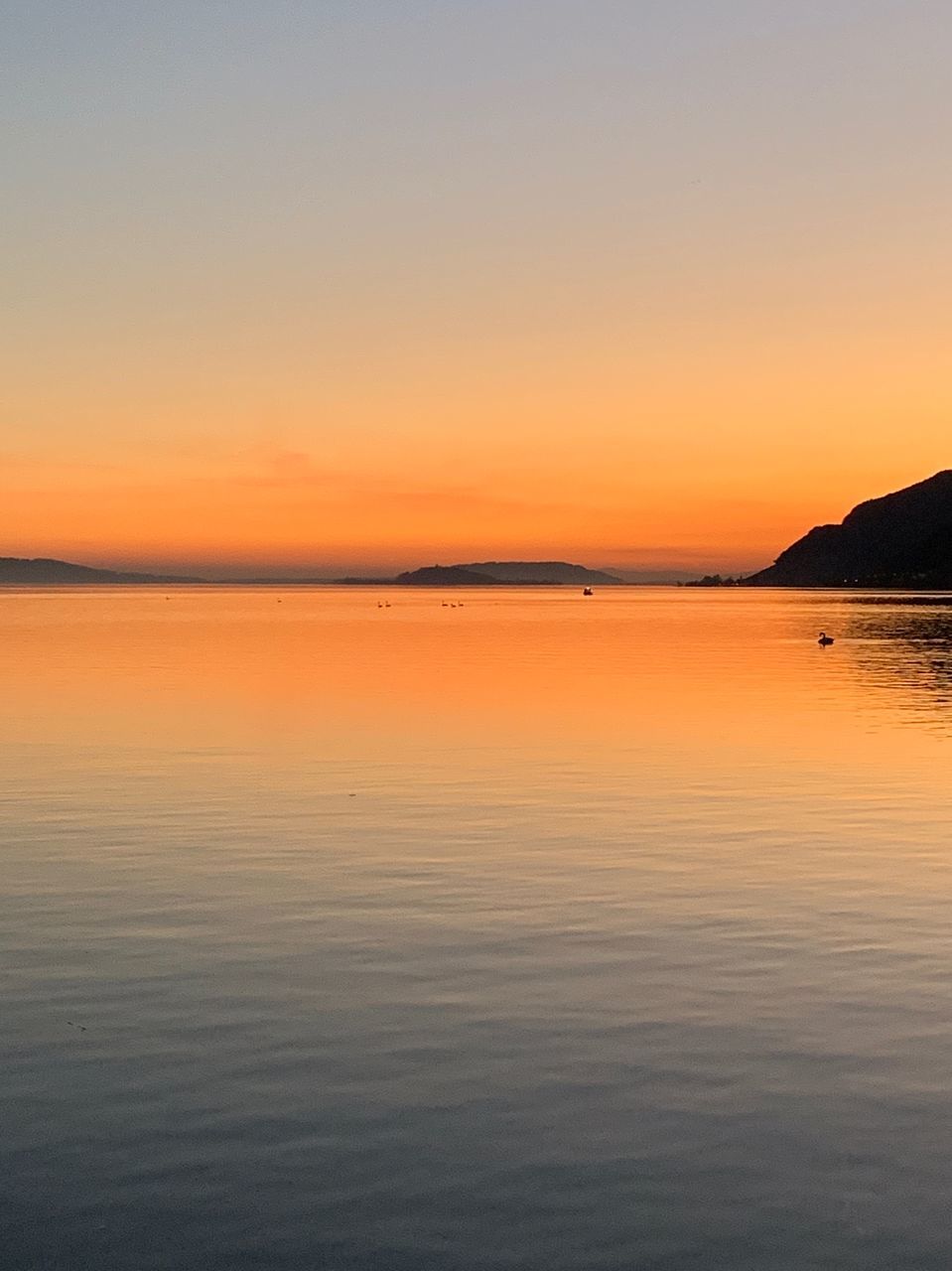 sunset, beauty in nature, sky, tranquility, scenics - nature, tranquil scene, water, waterfront, idyllic, orange color, sea, no people, copy space, nature, non-urban scene, reflection, mountain, horizon, clear sky, outdoors, romantic sky, salt flat