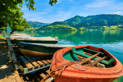 Boats moored in lake against sky