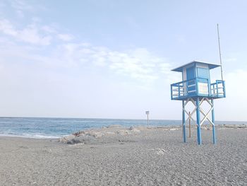 Lifeguard hut on beach against sky