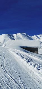 Scenic view of snowcapped mountains against clear blue sky