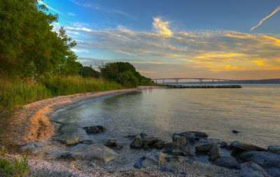 Scenic view of river against sky during sunset