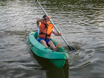 Rear view of men sitting on boat