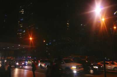 Illuminated street lights against sky at night