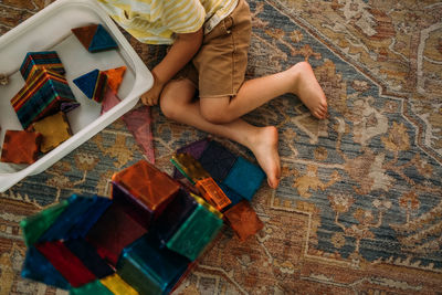 Overhead view of toddler building with magnet tiles