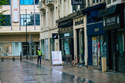 Reflection of building on wet street in city