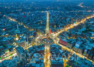 High angle view of illuminated ferris wheel in city at night