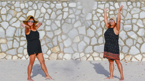 Full length of a woman standing against wall