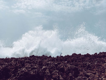 Panoramic view of sea waves splashing on rocks