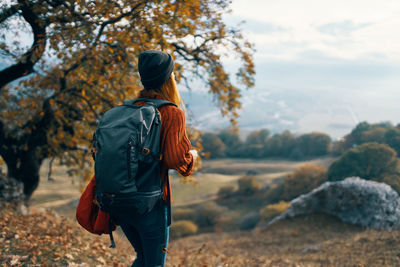 Rear view of woman standing on rock