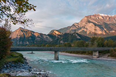 Bridge over river against mountains