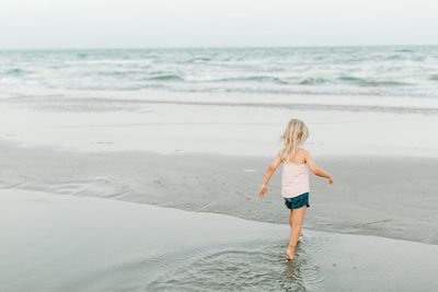 Full length of boy on beach against sky