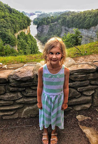 Portrait of girl standing against trees