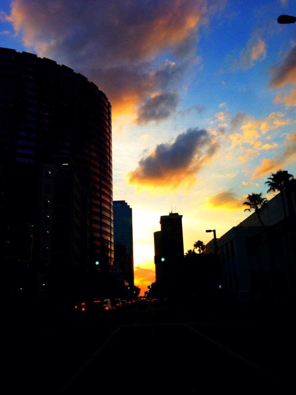 building exterior, architecture, sunset, built structure, city, sky, cloud - sky, orange color, building, silhouette, street, residential building, road, residential structure, dusk, car, outdoors, transportation, cloudy, cloud