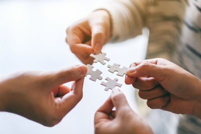 Cropped image of business people holding jigsaw pieces