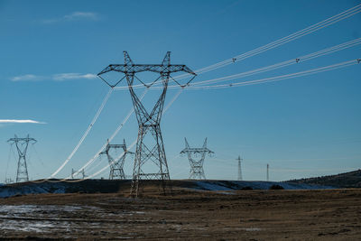 Electricity pylon on field against sky