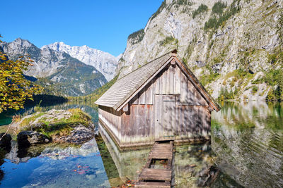 View of log cabin in lake against sky