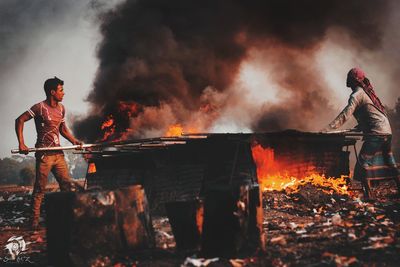 Low angle view of man standing against fire