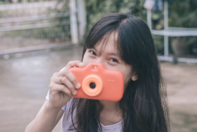 Portrait of girl holding camera