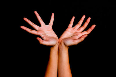 Close-up of human hand against black background