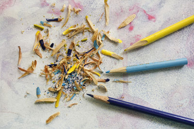 High angle view of colored pencils and shavings on table
