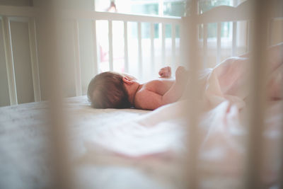 Close-up of baby sleeping on bed at home