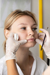 Close-up of woman applying medicine