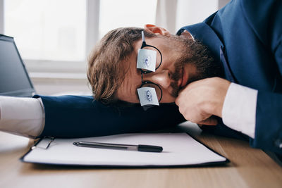 Businessman resting on table in office