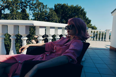 Side view of woman sitting on chair