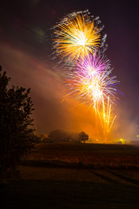 Low angle view of firework display at night