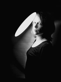 Portrait of a young woman looking away against wall